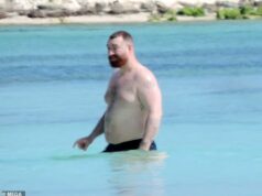 Sam Smith sem camisa mostra seu torso tatuado enquanto um amigo passa protetor photo voltaic em suas costas durante o dia à beira-mar após um present no México