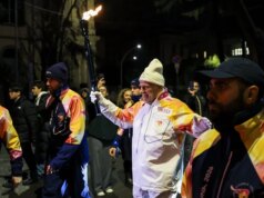 Tocha chega a Milão sob aplausos e protestos